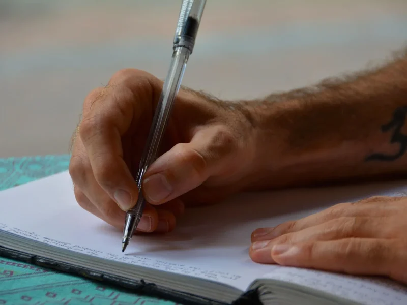 Dłoń zapisująca afirmacje w notesie