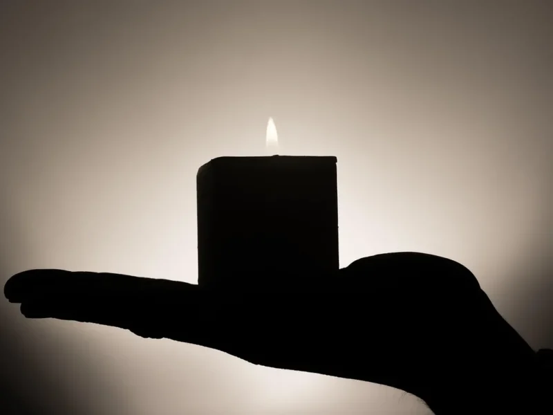 Sylwetka osoby w świetle świec podczas medytacji