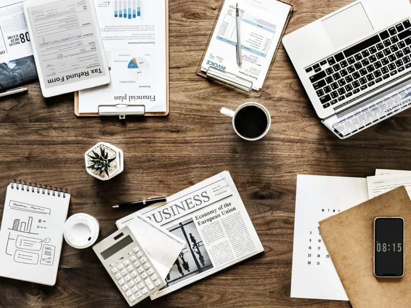 Biurko z notatnikiem, laptopem, dokumentami i kawą — planowanie produktywności